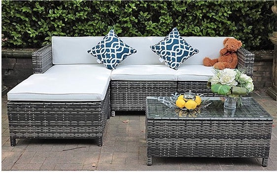 a lifestyle image of the grey rattan corner sofa and coffee table set in a garden